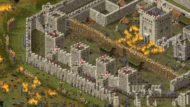 Attackers besiege a castle wall in Stronghold: Definitive Edition